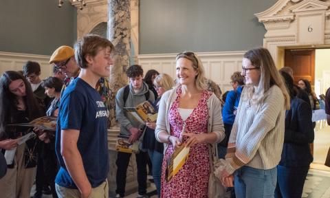 Student ambassador talking to a prospective student and their parent at an open day